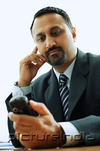PictureIndia - Businessman looking at PDA phone
