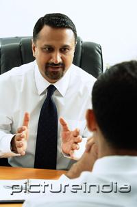 PictureIndia - Two businessmen in office talking