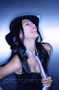 PictureIndia - Young woman, wearing hat and tie, laughing