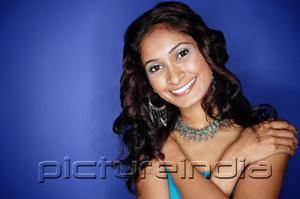 PictureIndia - Woman with arms crossed over chest, smiling at camera