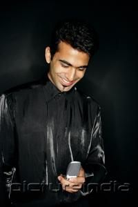PictureIndia - Man looking at mobile phone, smiling
