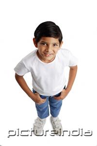 PictureIndia - Boy standing with hands in pocket, smiling at camera