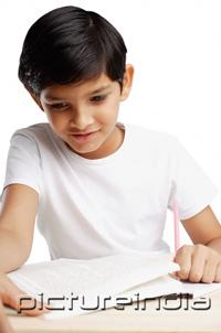 PictureIndia - Boy looking at book and writing
