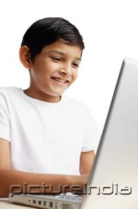 PictureIndia - Boy using laptop, smiling