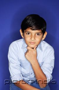 PictureIndia - Boy looking at camera, hand on chin, portrait