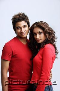 PictureIndia - Couple standing side by side, looking at camera
