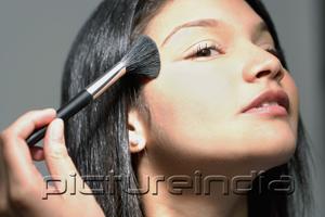 PictureIndia - Woman applying make-up with make up brush