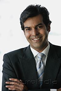 PictureIndia - Businessman smiling at camera, arms crossed