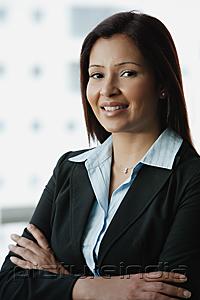 PictureIndia - Businesswoman smiling at camera, arms crossed