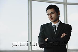 PictureIndia - Young businessman arms crossed