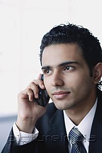 PictureIndia - Young businessman with mobile phone, head shot