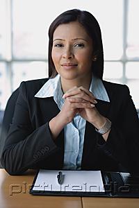 PictureIndia - Businesswoman looking at camera, hands clasped